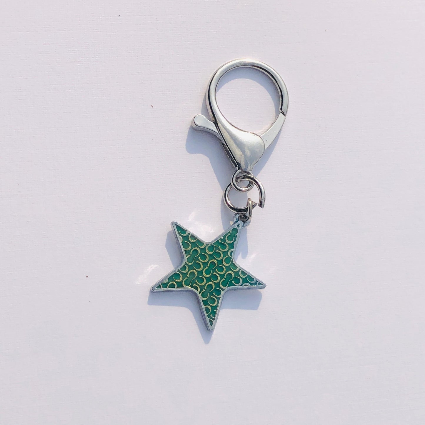 Star-shaped keychain with a silver ring on a light gray background