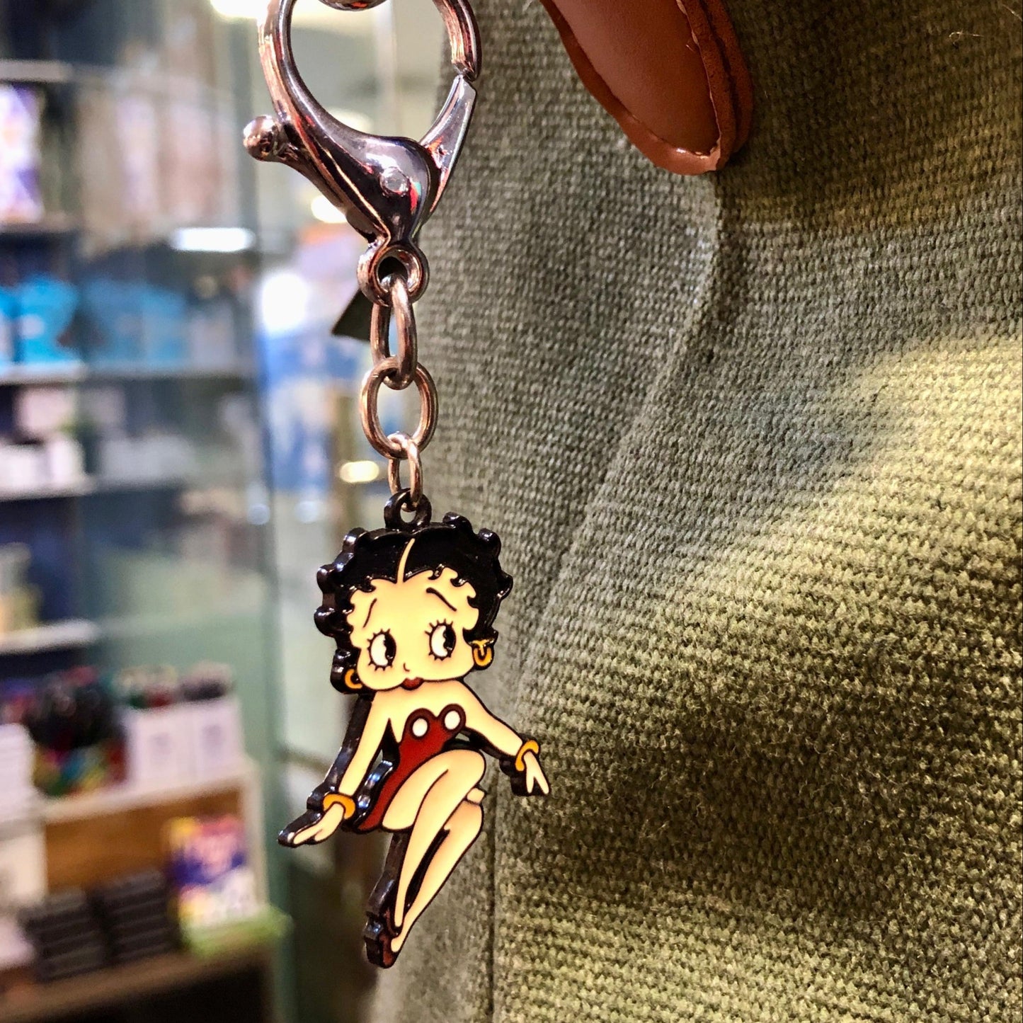 Keychain with a character charm attached to a bag in a store setting