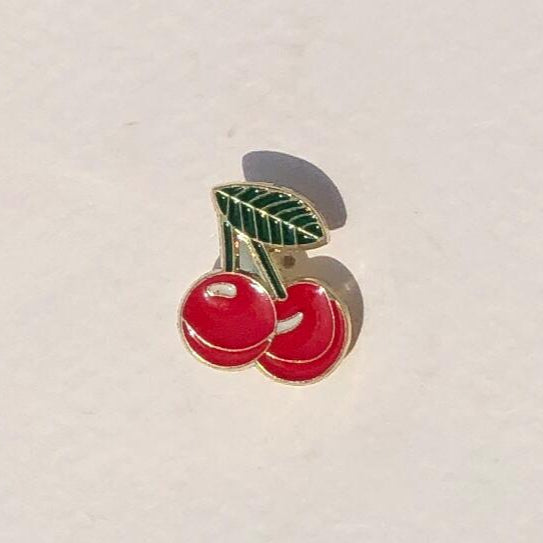 Cherry-themed pin on a light beige background