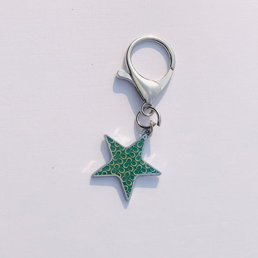 Star-shaped keychain with a silver ring on a light gray background
