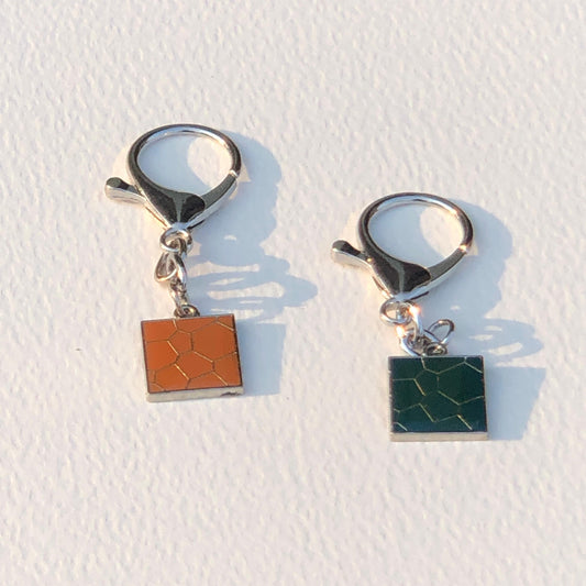 Pair of earrings with square charms on a white background