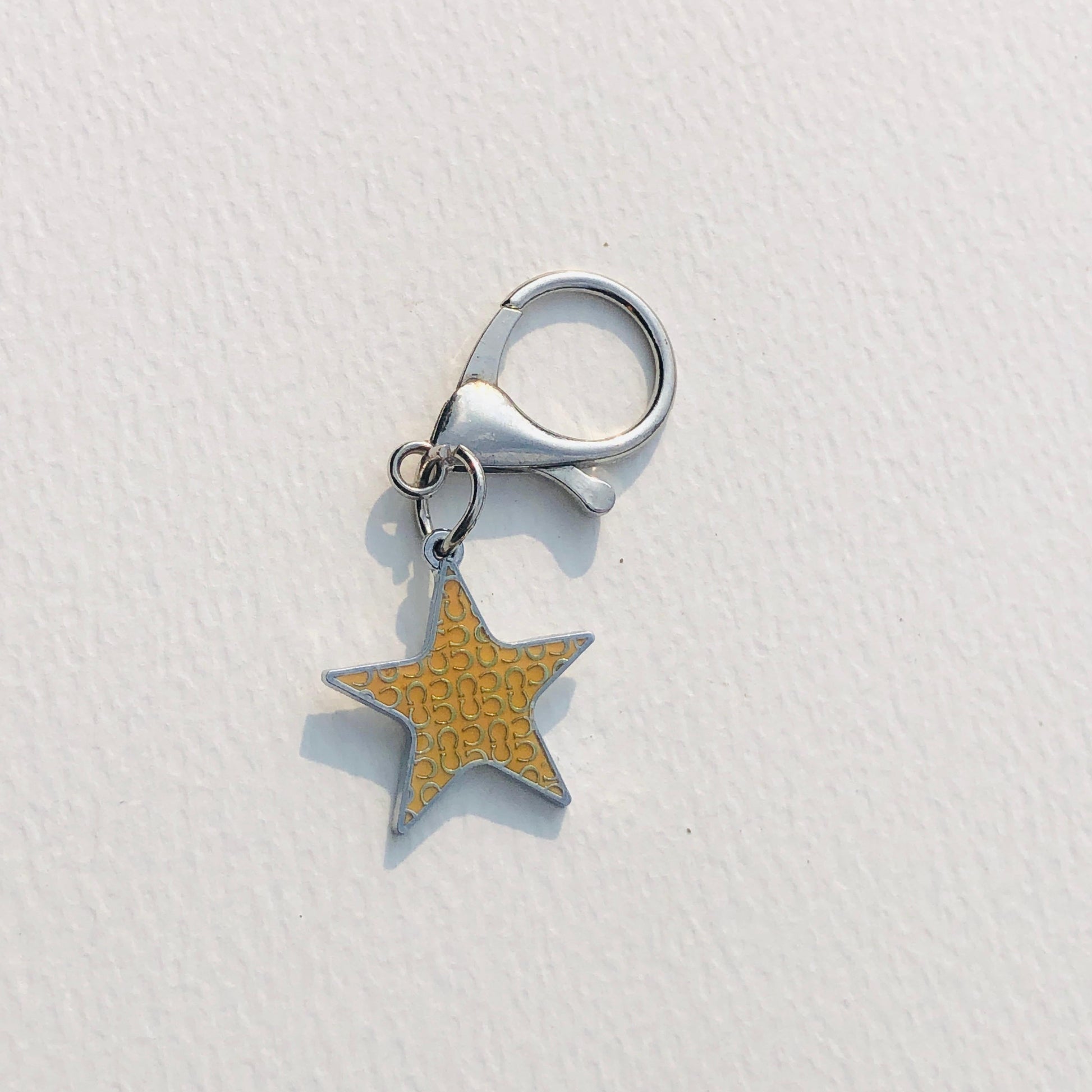Star-shaped charm with textured surface on a white background