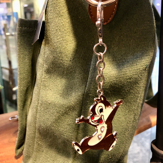 Keychain with a cartoon character attached to a green bag.