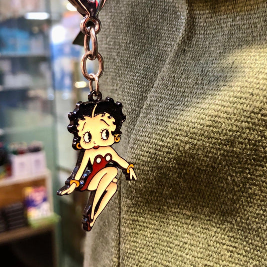 Keychain with a character charm attached to a bag in a store setting
