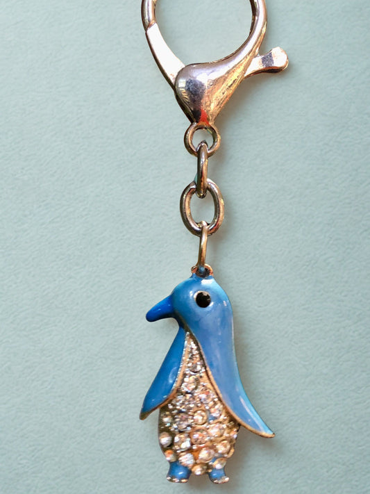 Penguin-shaped keychain charm on a light blue background