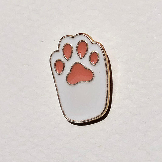 Paw print-shaped pin with red pads on a light gray background