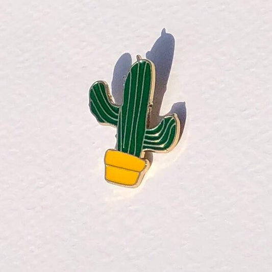 Cactus-shaped pin on a textured white background