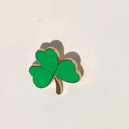 Green shamrock-shaped pin on a white background