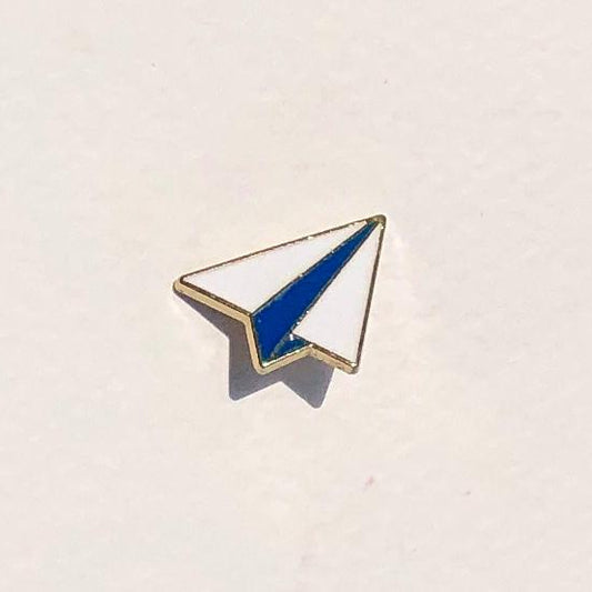 Pin with blue and white design on a beige background