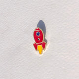 Red and yellow rocket-shaped pin on a textured white background