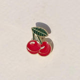 Cherry-themed pin on a light beige background